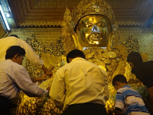 Des feuilles d'or sont collées sur la statue de Bouddha