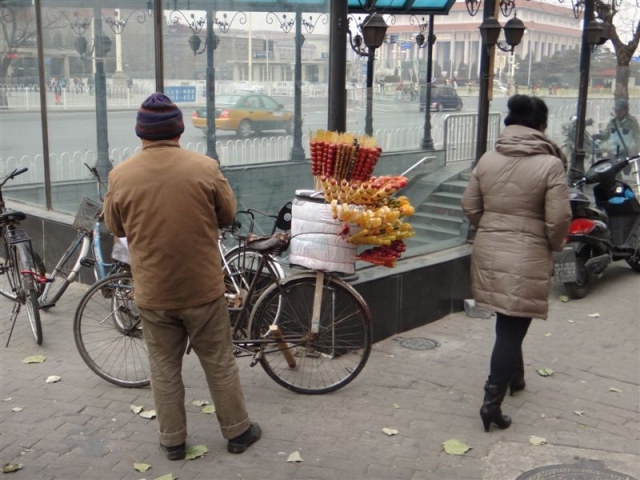 vendeur ambulant de brochettes de fruits caramélisés